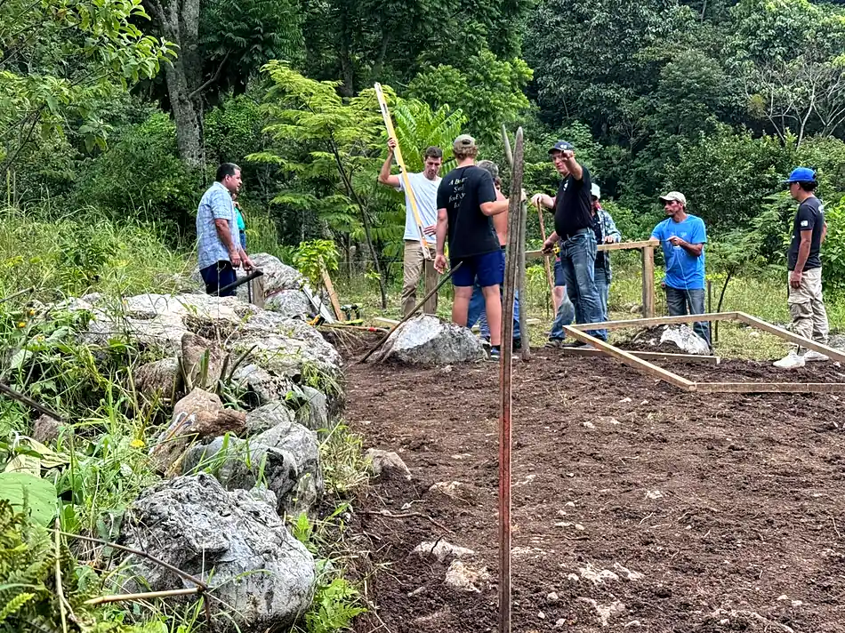 Our team and farm workers setting out timber frames on cleared ground at the farm